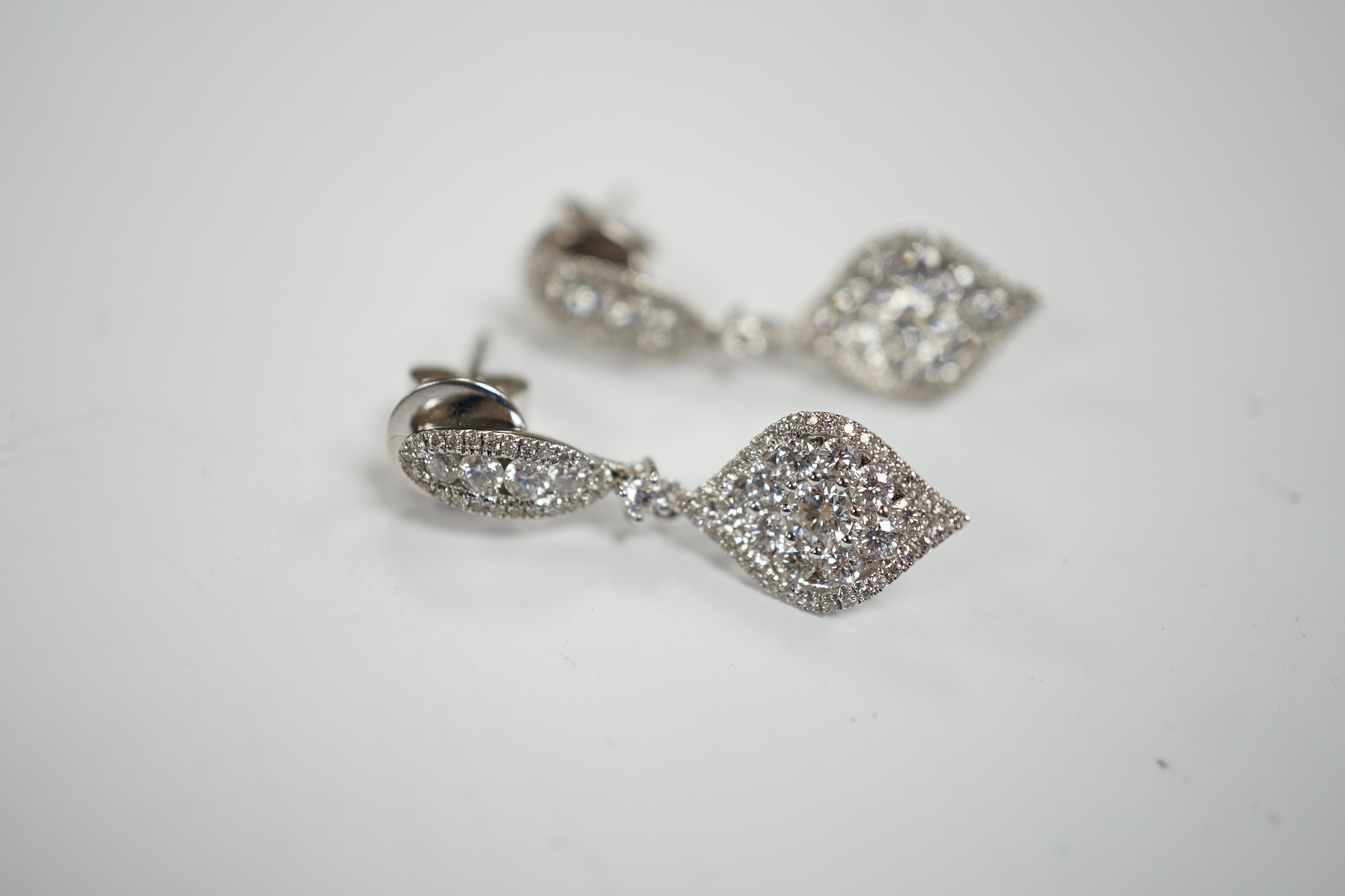 A modern pair of 750 white metal and diamond cluster set drop earrings, of elliptical form, 26mm, gross weight 4.1 grams.